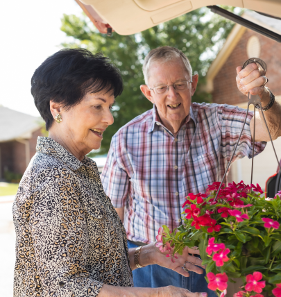 two concordia residents admiring a pot of flowers