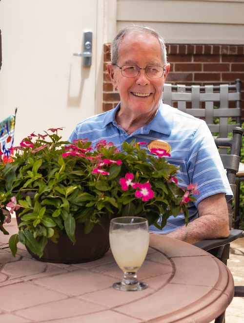 a concordia resident smiling while holding a flower pot