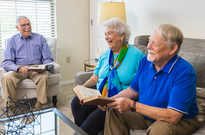 three Concordia life plan community residents reading a book together