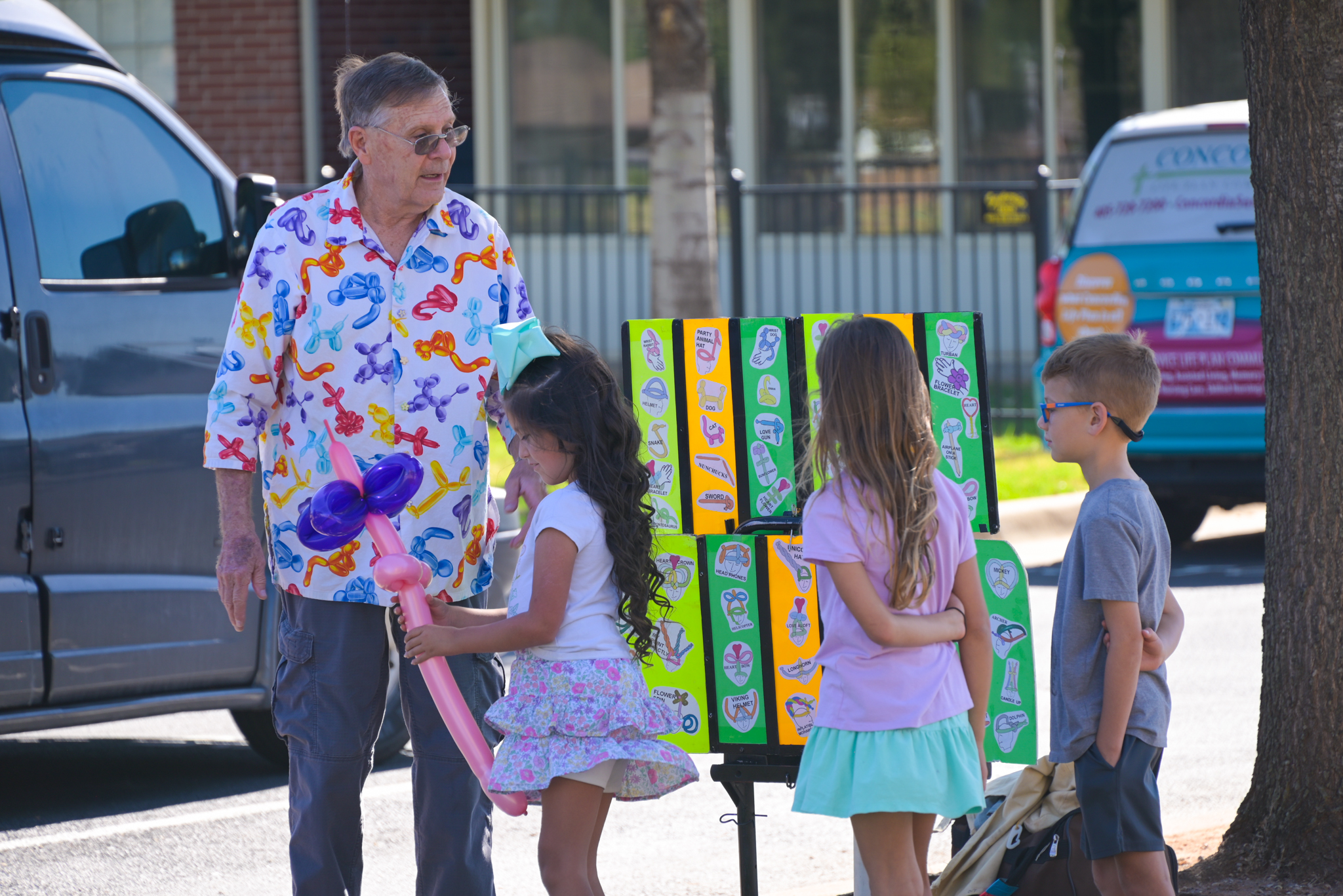 an older man standing outside with three children