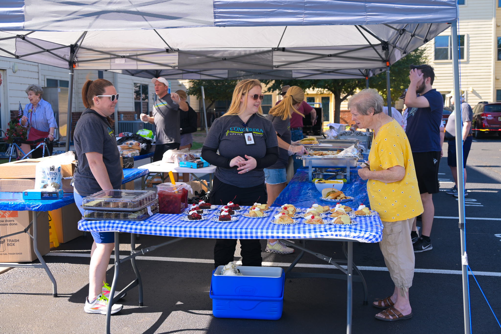 three women standing around a table of baked goods