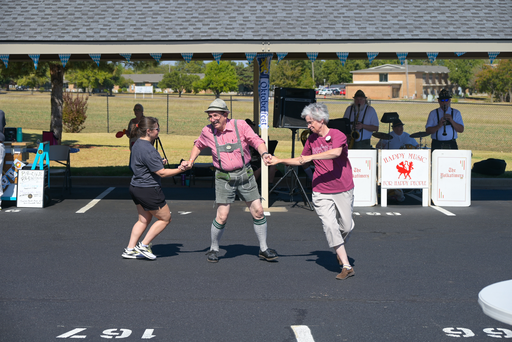 a man and two women dancing to music outside